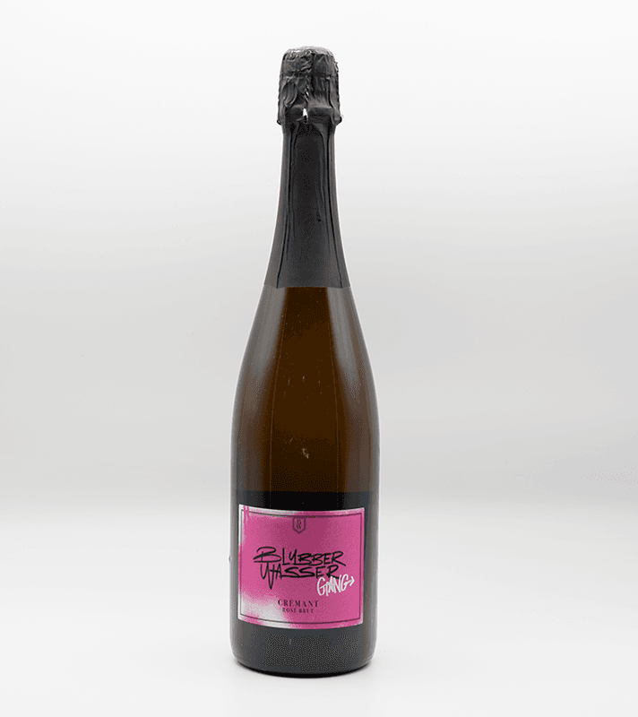 Sektflasche mit schwarzem Verschluss und pinkem Etikett, das den Namen "Blubber Wasted Gang" und "Crement Rose Brut" zeigt, steht auf einem weißen Hintergrund.