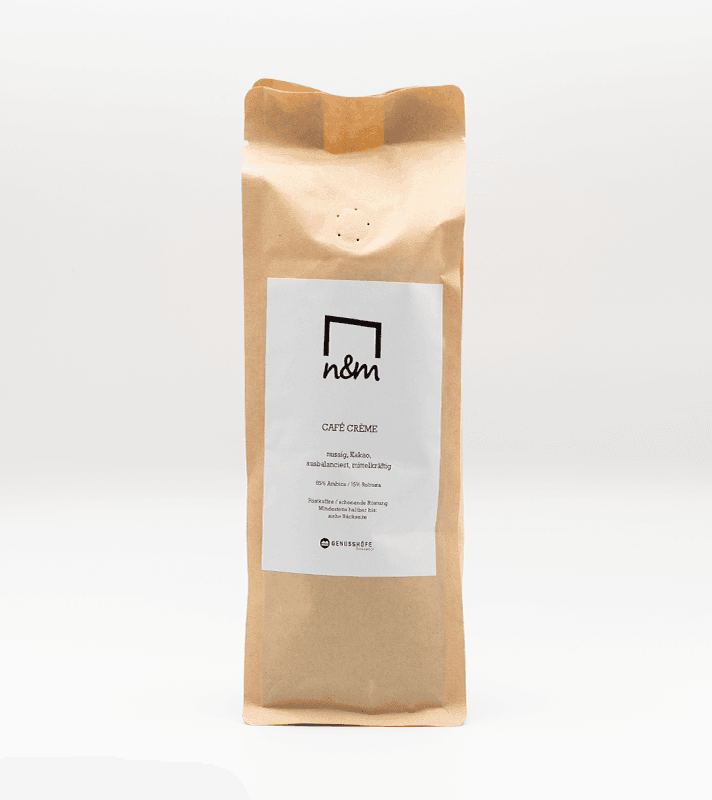 Papiertüte mit Kaffeecreme, auf der ein weißes Etikett mit schwarzem Logo und Text angebracht ist, steht auf einem weißen Hintergrund.