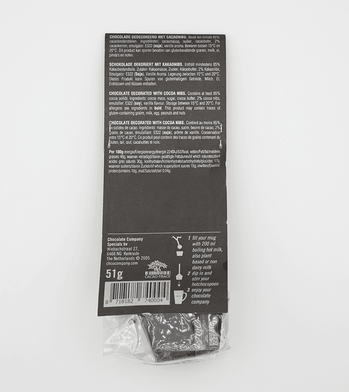 Schokoladentafel mit Kakaoanteil, dekoriert mit Kakao Nibs, in schwarzer Verpackung mit weißen Texten, enthält 51 g, Anleitung zum Zubereiten mit Milch oder Wasser.
