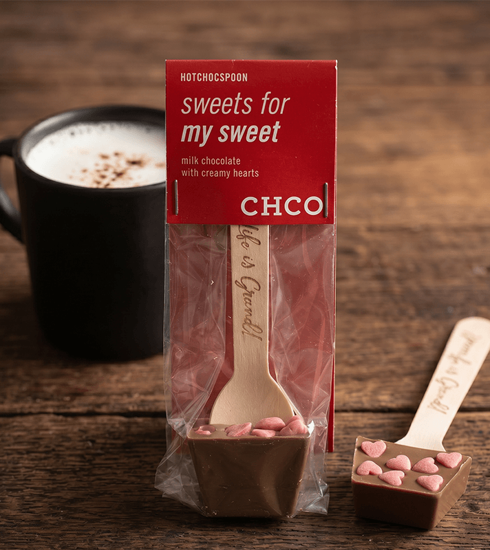 Schokoladenlöffel mit cremigen Herzen und pinken Zuckerstücken, verpackt in rotem Karton mit Aufschrift "sweets for my sweet" und "milk chocolate".
