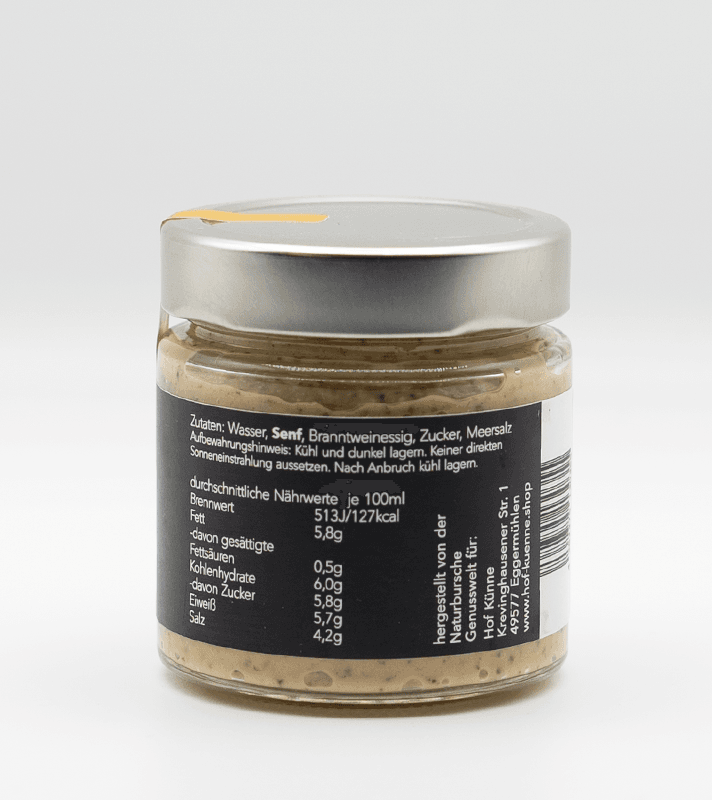 Glas mit Senf, sichtbarer Körnigkeit, mit schwarzem Etikett, das Nährwerte und Zutaten auflistet, und silberner Deckel.