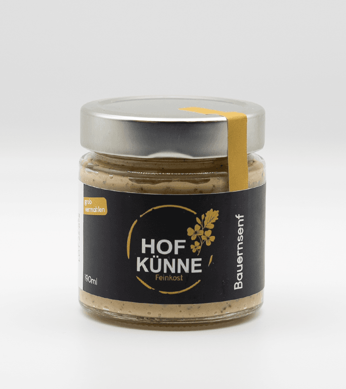 Glas jar mit schwarzem Etikett, goldener Schrift und Blütenlogo, enthält Hof Küne Feinkost Bausenf, 190 ml, mit silberner Metallkappe und gelber Band.