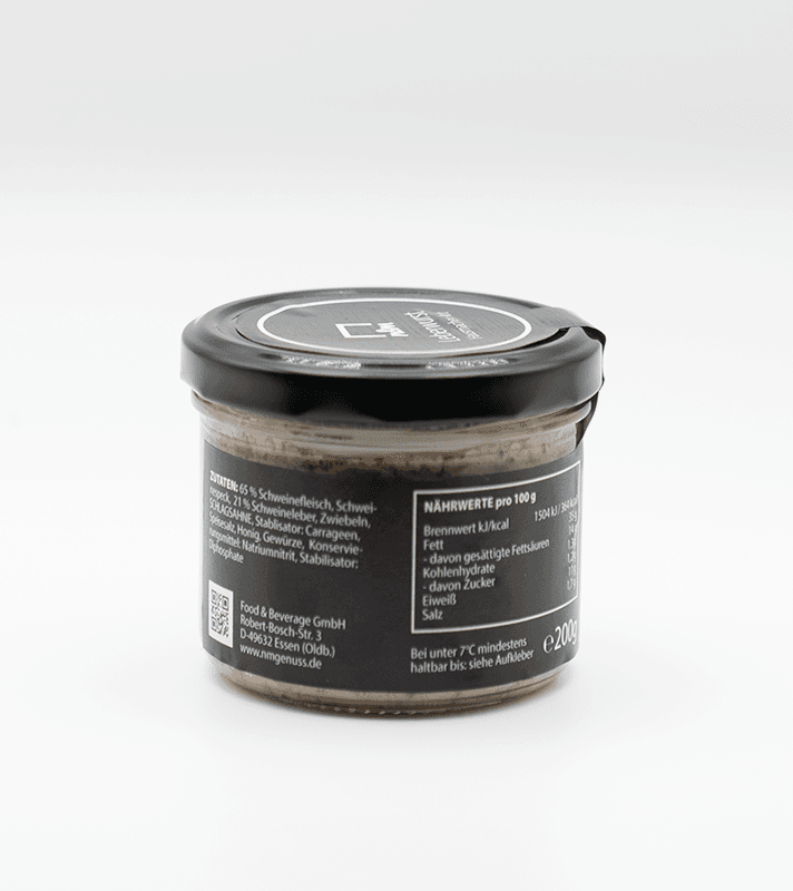 Kleines Glas mit schwarzem Deckel, enthält eine cremige, braune Paste, vermutlich Fleisch- oder Wurstaufstrich, mit Nährwertangaben und Zutaten auf der Rückseite.