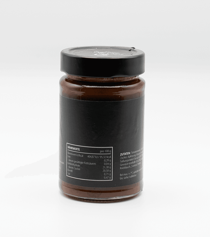 Glas jar mit schwarzem Deckel, gefüllt mit brauner Paste oder Creme, schwarzes Etikett mit Nährwertangaben und Zutaten auf der Rückseite.