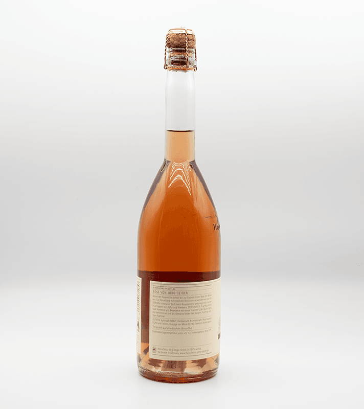 Schwacher Roséwein in einer klaren Flasche mit Korkverschluss, hellrosa Farbe, Etikett mit Text auf der Rückseite.