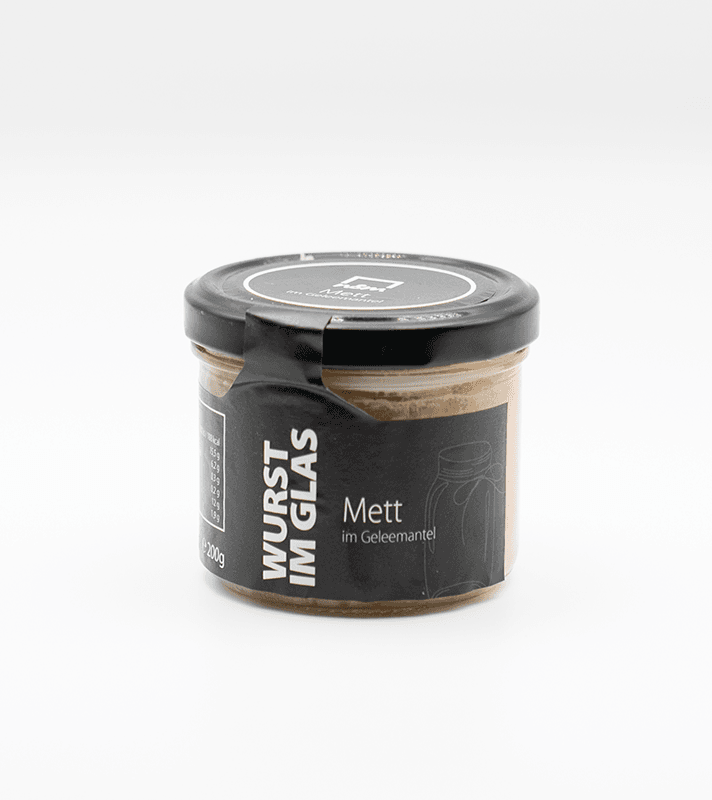 Glas mit Honig im Gelee-Deckel, schwarzer Etikett mit weißen Schriftzügen, beschreibt Honig im Glas, das Produkt ist 200 g schwer.