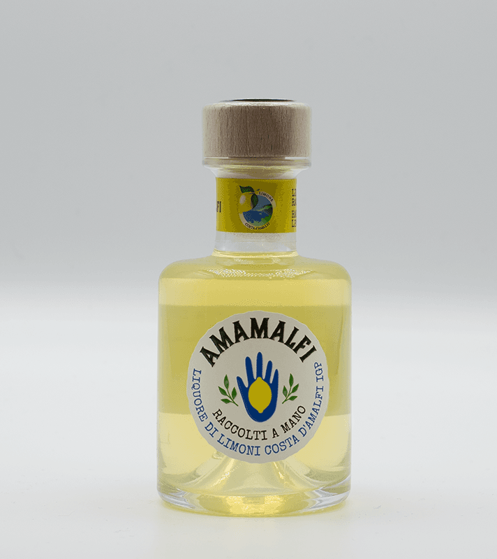 Kleines Fläschchen mit gelber Zitronenlimonade, weißem Etikett mit blauer Hand und grünen Lorbeerzweigen, Holzdeckel, handgemacht, Costa d'Amalfi.